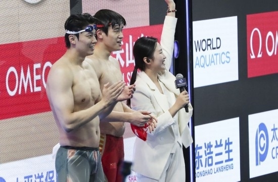  10月18日，汪順（左）和潘展樂在男子100米混合泳決賽后。新華社記者 方喆 攝