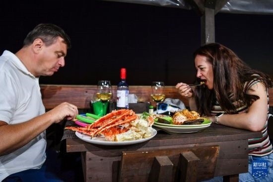 9月2日，食客們?cè)诙砹_斯符拉迪沃斯托克的一家餐館品嘗帝王蟹。新華社記者 曹陽(yáng) 攝