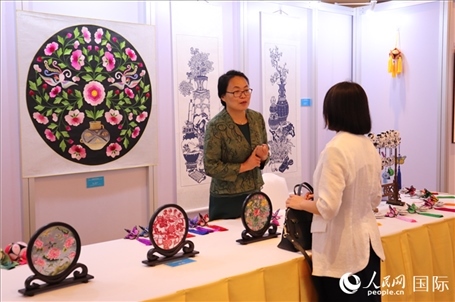 青海非遺文化傳承人向嘉賓介紹展品。人民網(wǎng)實(shí)習(xí)生姚欣可攝