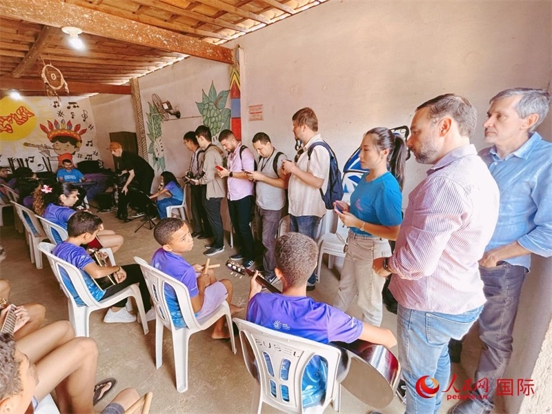  受益于中國企業(yè)的“青少年成長”項目，700多名當(dāng)?shù)厍嗌倌甑囊魳泛妥闱驂粝氩迳狭顺岚?。圖為聯(lián)合采訪團正在采訪參加音樂培訓(xùn)的孩子們。 人民網(wǎng)記者 陳一鳴攝