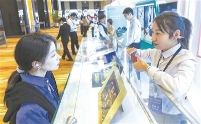 在北京麗澤商務(wù)區(qū)，工作人員（右一）介紹數(shù)字人民幣SIM卡硬錢包。新京報記者 陶冉攝