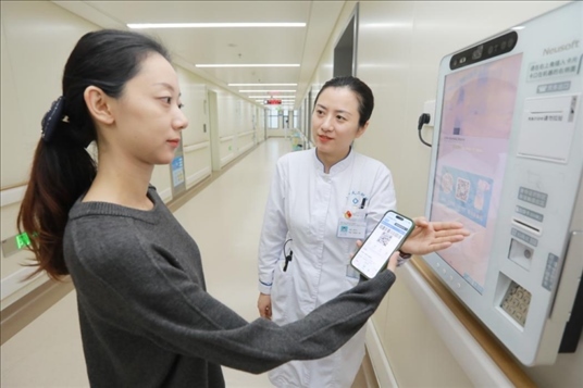 醫(yī)護(hù)人員引導(dǎo)患者在自助機(jī)前辦理自助入院手續(xù)。圖片來(lái)源：山東第一醫(yī)科大學(xué)第二附屬醫(yī)院