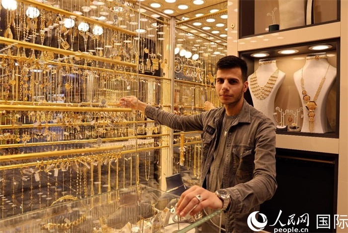 一名銷售員展示黃金飾品。人民網(wǎng) 伊納斯·易卜拉欣攝