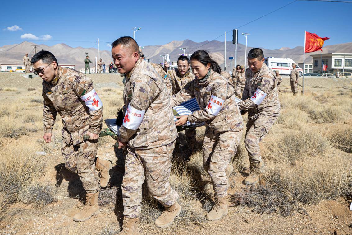 1月9日，日喀則定日縣長所鄉(xiāng)，西藏軍區(qū)總醫(yī)院醫(yī)療隊隊員將受傷村民用擔(dān)架從救護車準(zhǔn)備抬上直升機，轉(zhuǎn)運至拉薩的西藏軍區(qū)總醫(yī)院救治。人民日報記者張武軍攝