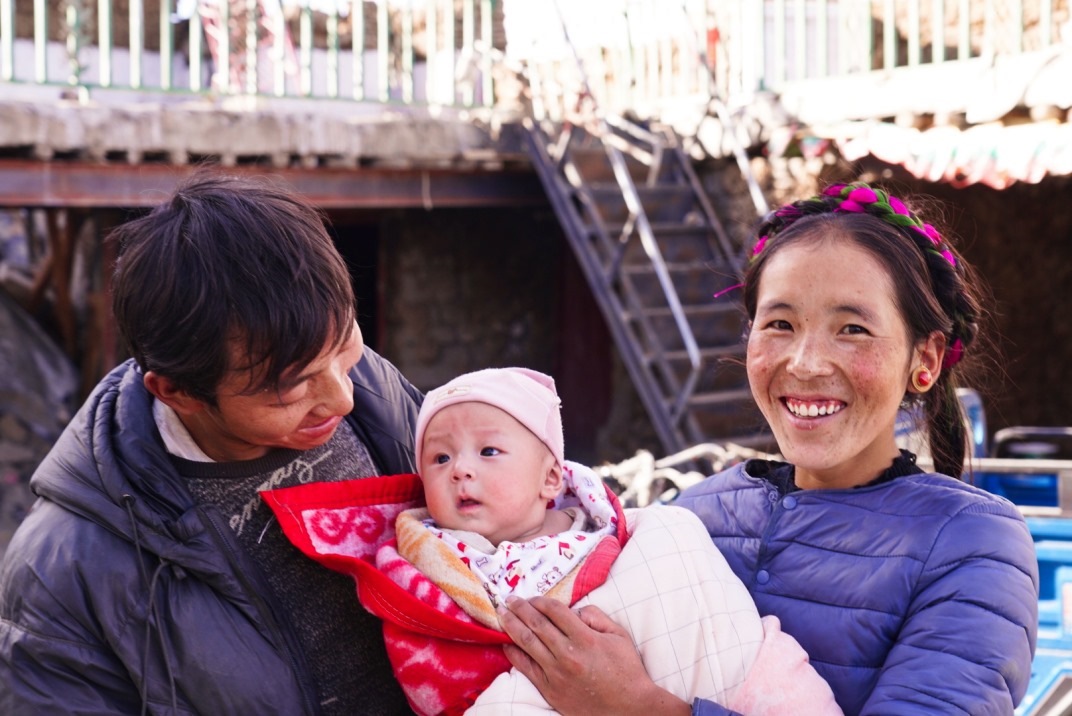 1月11日，在西藏日喀則市人民醫(yī)院，受災(zāi)群眾抱著自己在地震中受傷的孩子康復(fù)出院。人民日報記者徐馭堯攝