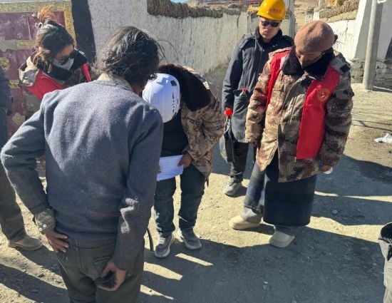 1月13日，次旺（右一）陪同工作組走訪村莊，評估房屋受損程度。新華社發(fā)