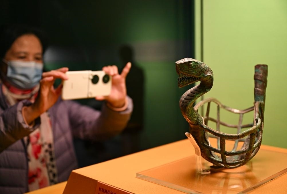 1月14日，觀眾在上海博物館蛇年迎春展拍攝展品蛇綱網(wǎng)狀銅器。新華社發(fā)（陳浩明攝）