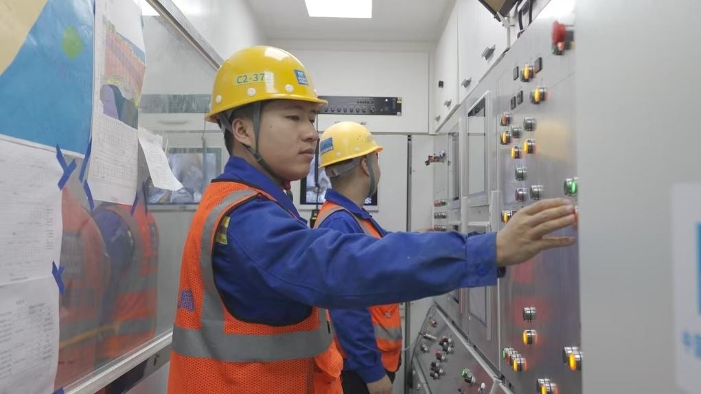 盾構(gòu)司機(jī)何曉波在駕駛室內(nèi)調(diào)試盾構(gòu)機(jī)參數(shù)。（劉芬攝）