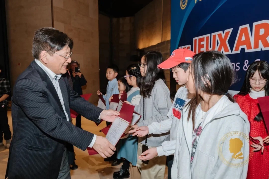 圖2：亞丁為獲獎兒童頒發(fā)證書。法中交流促進(jìn)會供圖