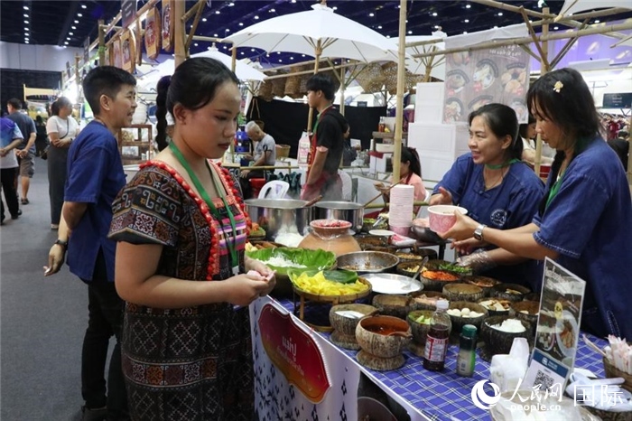 游客在攤位前購(gòu)買特色美食。朱瀟逸攝