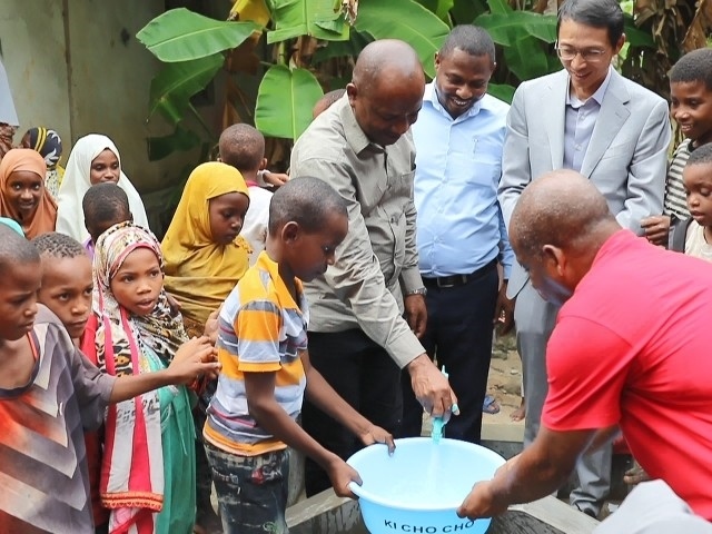 在日前舉行的安全供水工程揭牌儀式上，當(dāng)?shù)匦∨笥言诠┧c(diǎn)接水。 施亮攝