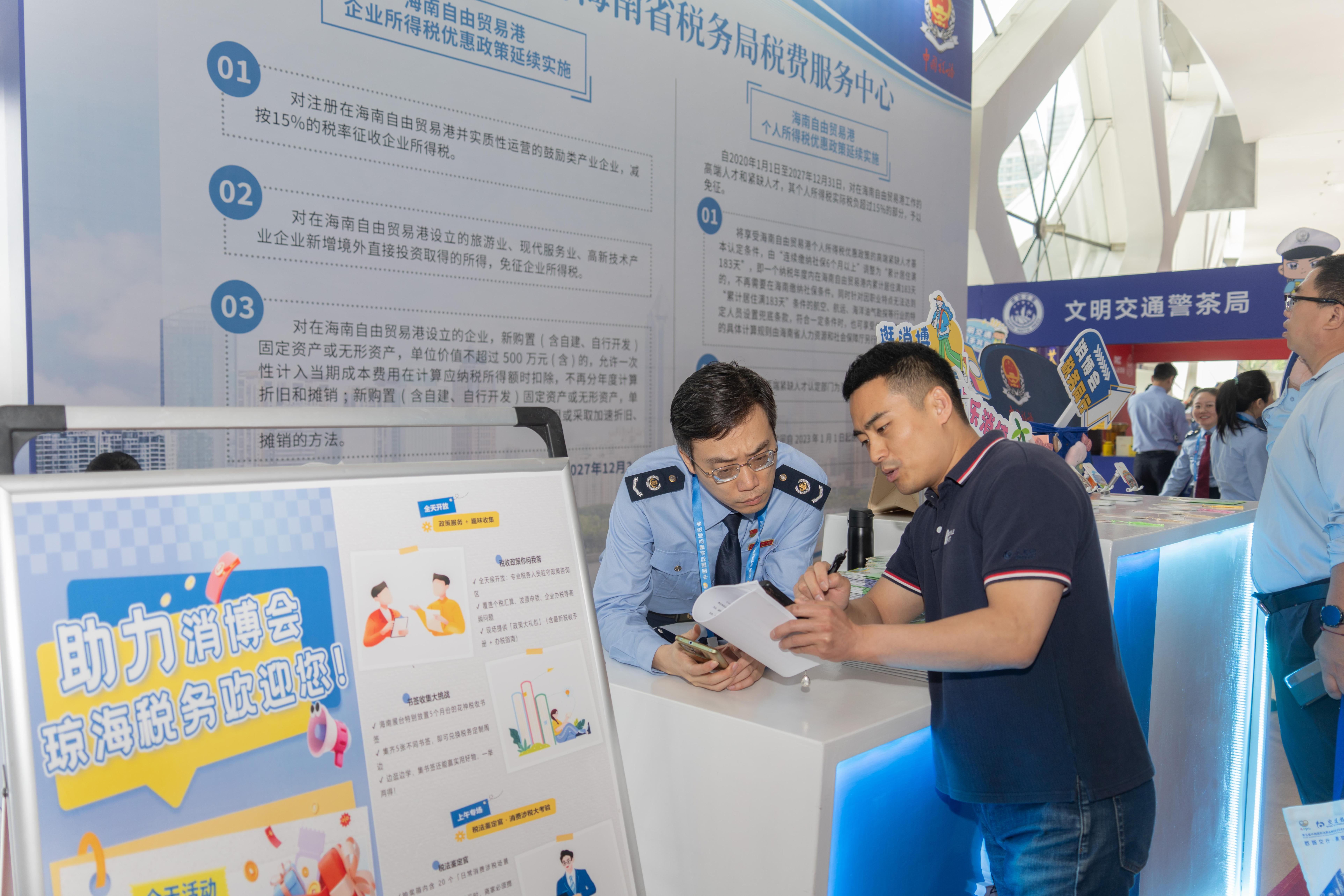 稅務(wù)服務(wù)臺(tái)工作人員向記者介紹服務(wù)參展外商的具體舉措。人民網(wǎng)記者 許崢攝