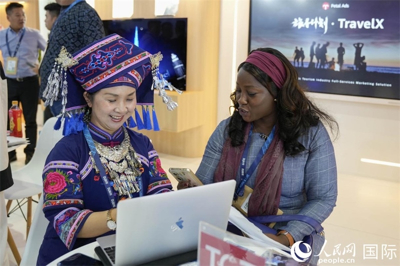 來自廣西的旅游業(yè)者同客戶交流。人民網(wǎng)塔里克·易卜拉欣攝