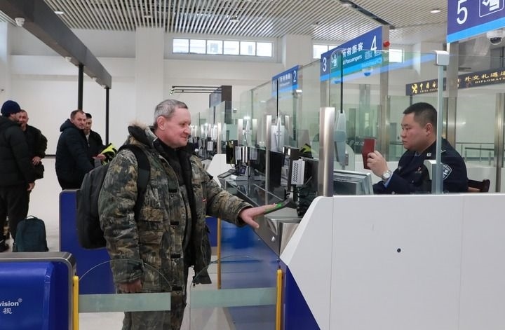 2024年12月10日，在黑河公路口岸旅檢大廳，黑河出入境邊防檢查站民警為首班次客車入境旅客辦理邊檢通關(guān)手續(xù)。當(dāng)日，中國(guó)黑河公路口岸—俄羅斯卡尼庫爾干公路口岸旅客運(yùn)輸正式開通。新華社發(fā)（劉松攝）