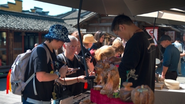 “五一”期間，游客正在烏鎮(zhèn)“水鄉(xiāng)碼頭”挑選購買文創(chuàng)產(chǎn)品。受訪者供圖