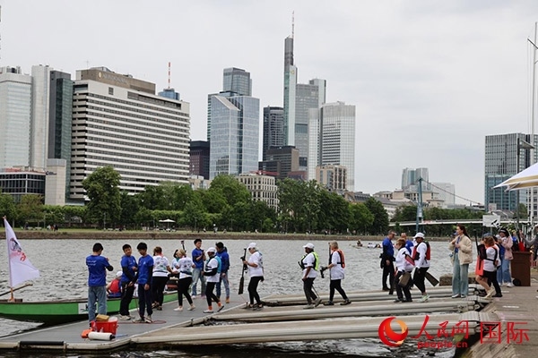 來自美國的快樂龍舟隊(duì)選手們正在登船準(zhǔn)備參賽。人民網(wǎng)記者 劉仲華攝