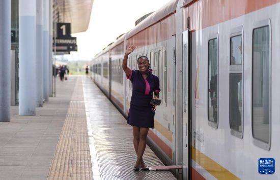 5月31日，在蒙內鐵路內羅畢站，一名乘務員在即將開往蒙巴薩的E2次列車旁等候乘客。新華社記者 李亞輝 攝