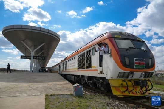 5月31日，在蒙內鐵路內羅畢站，機車駕駛員蔣立平（右）和博爾在即將開往蒙巴薩的E2次列車上揮手致意。新華社記者 楊光 攝