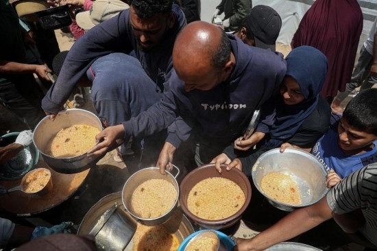 5月28日，人們在加沙城西部的沙提難民營領取救助食物。新華社發(fā)（里澤克·阿卜杜勒賈瓦德攝）